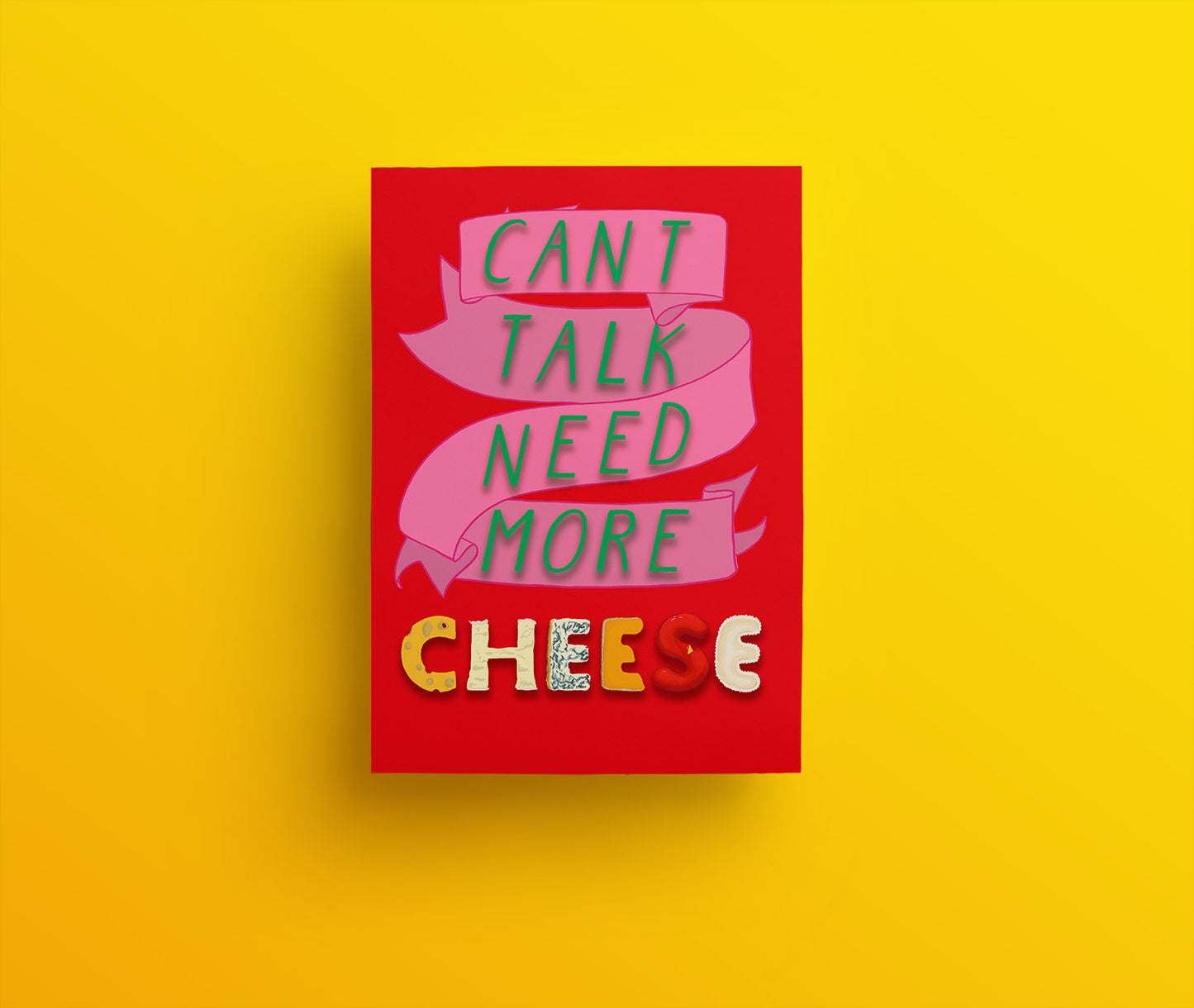 A red christmas card with a pink ribbon and beautifully cheesily, festively decorated green, yellow and red words saying "Can't talk. Need more cheese."