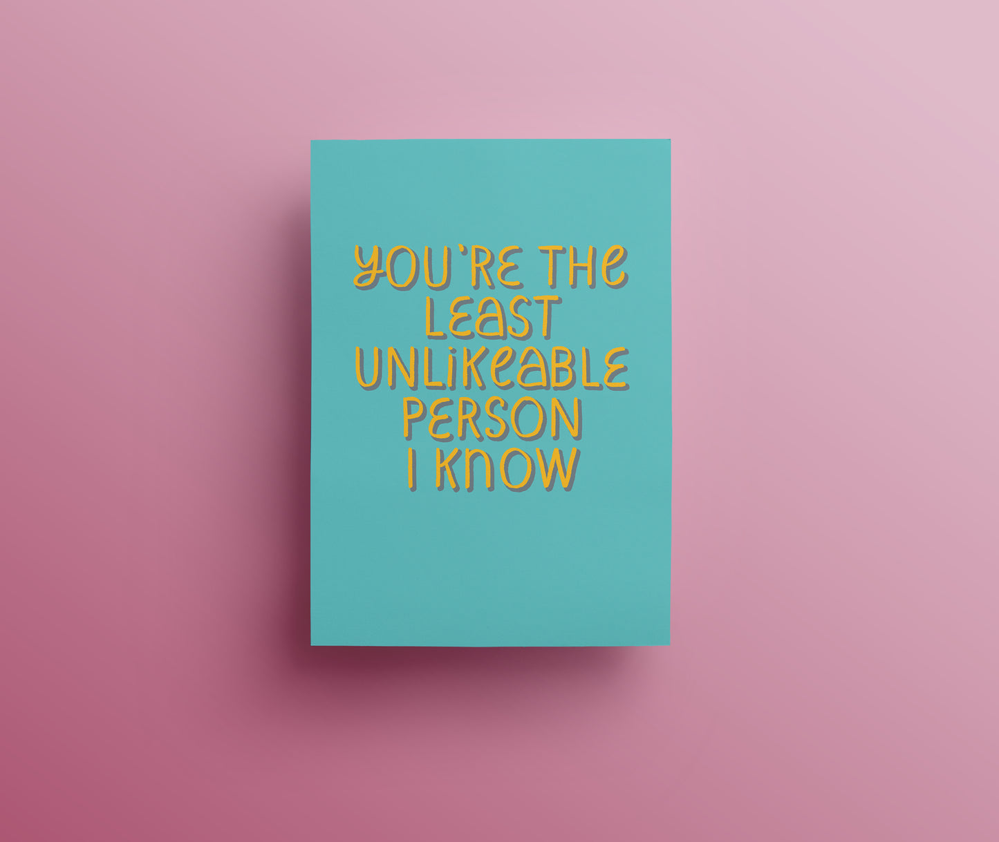 Turquoise greetings card with yellow and blue hand drawn lettering saying 'You're the least unlikeable person I know."