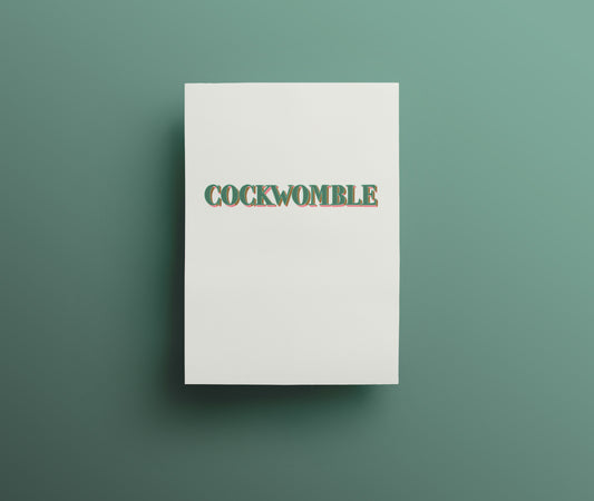 A sweary greetings card with the word 'COCKWOMBLE' designed with hand drawn lettering written in green and pink capital letters on white background.
