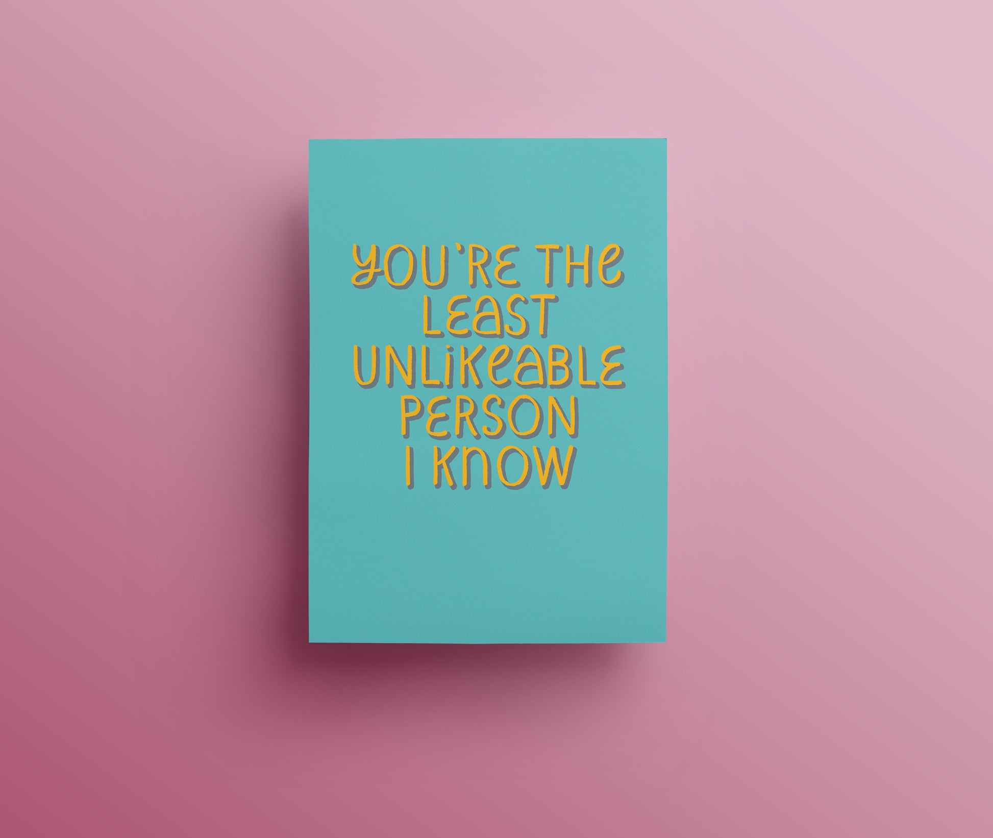 Turquoise greetings card with yellow and blue hand drawn lettering saying 'You're the least unlikeable person I know."