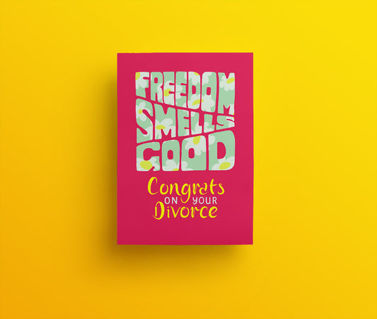 Raspberry greetings card with light green and daisy covered hand drawn lettering spelling out 'Freedom Smells Good. Congrats on your divorce.'