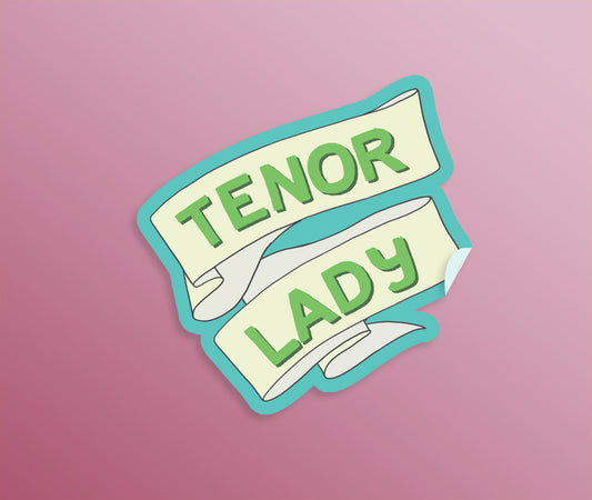 A die-cut sticker with a ribbon with hand drawn lettering on it in turquoise and green saying "Tenor Lady"